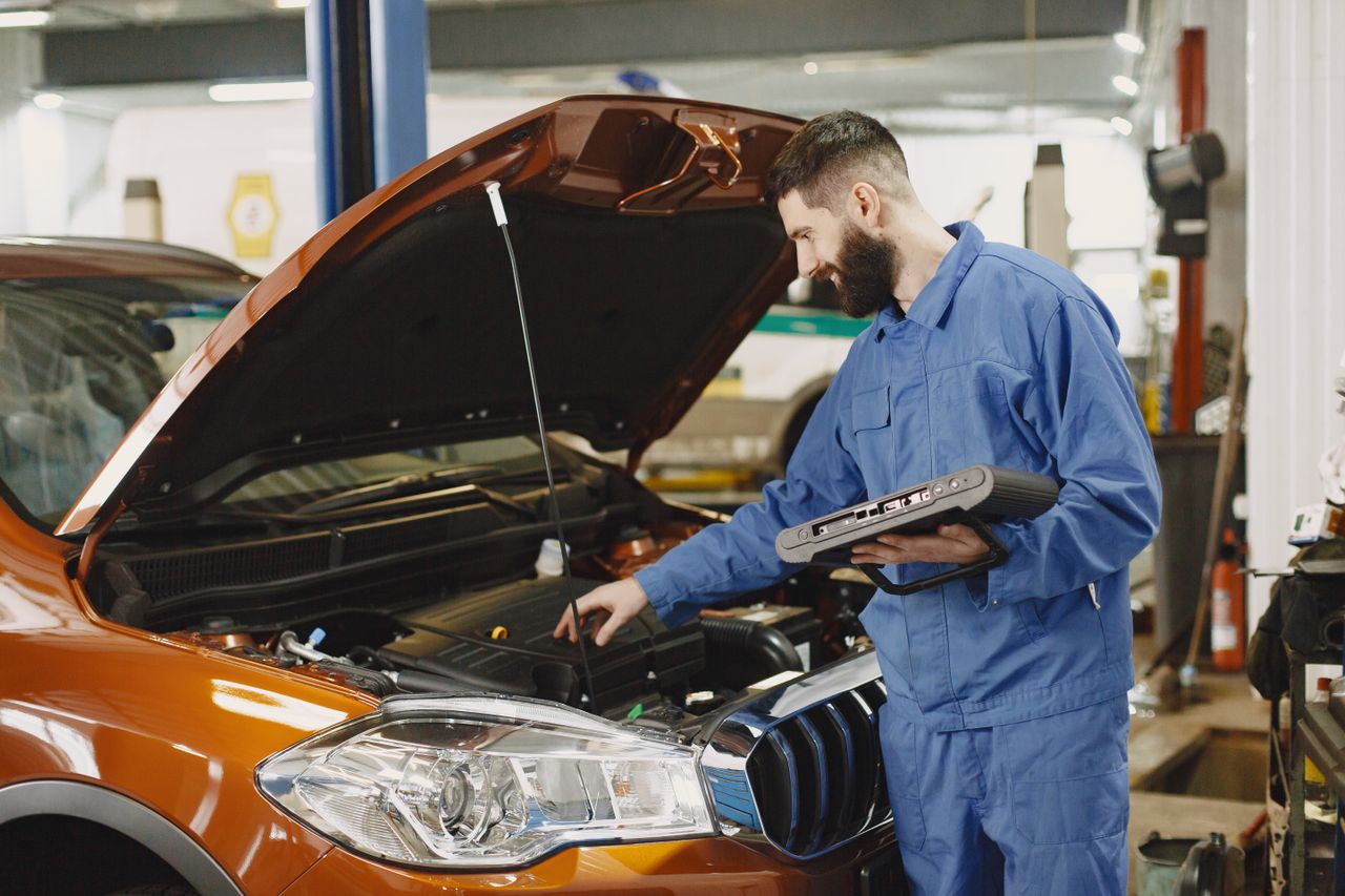 Mehaničar pregleda automobil dok traje prenos vlasništva vozila
